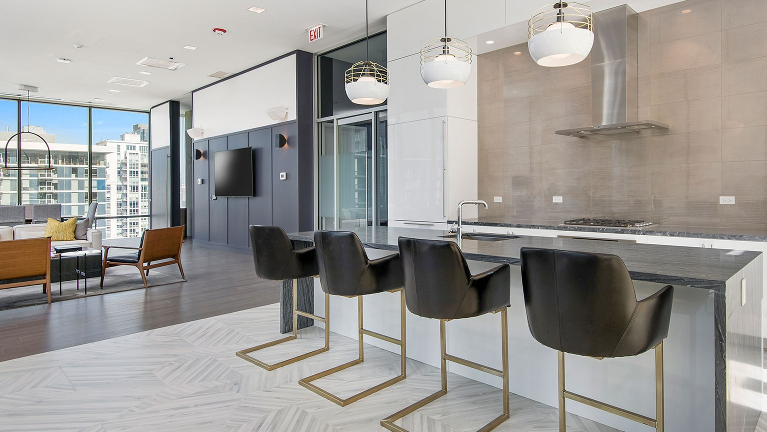 A stylish community kitchen and lounge area at Hubbard 221, featuring a large island, bar seating, and modern design