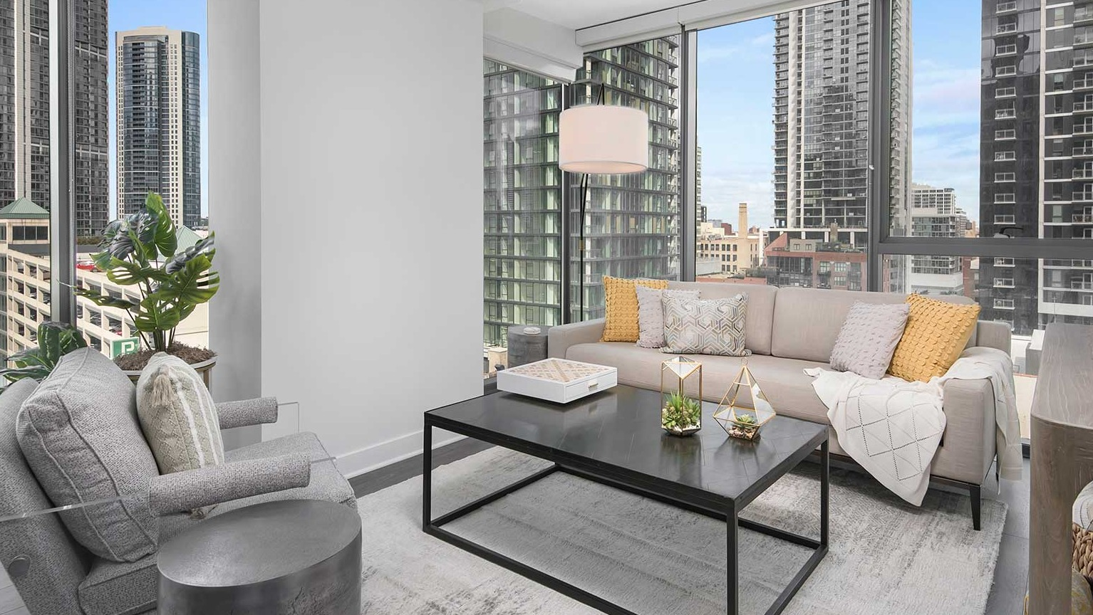 A comfortable living room at Hubbard 221, boasting modern furniture and expansive windows with a city backdrop