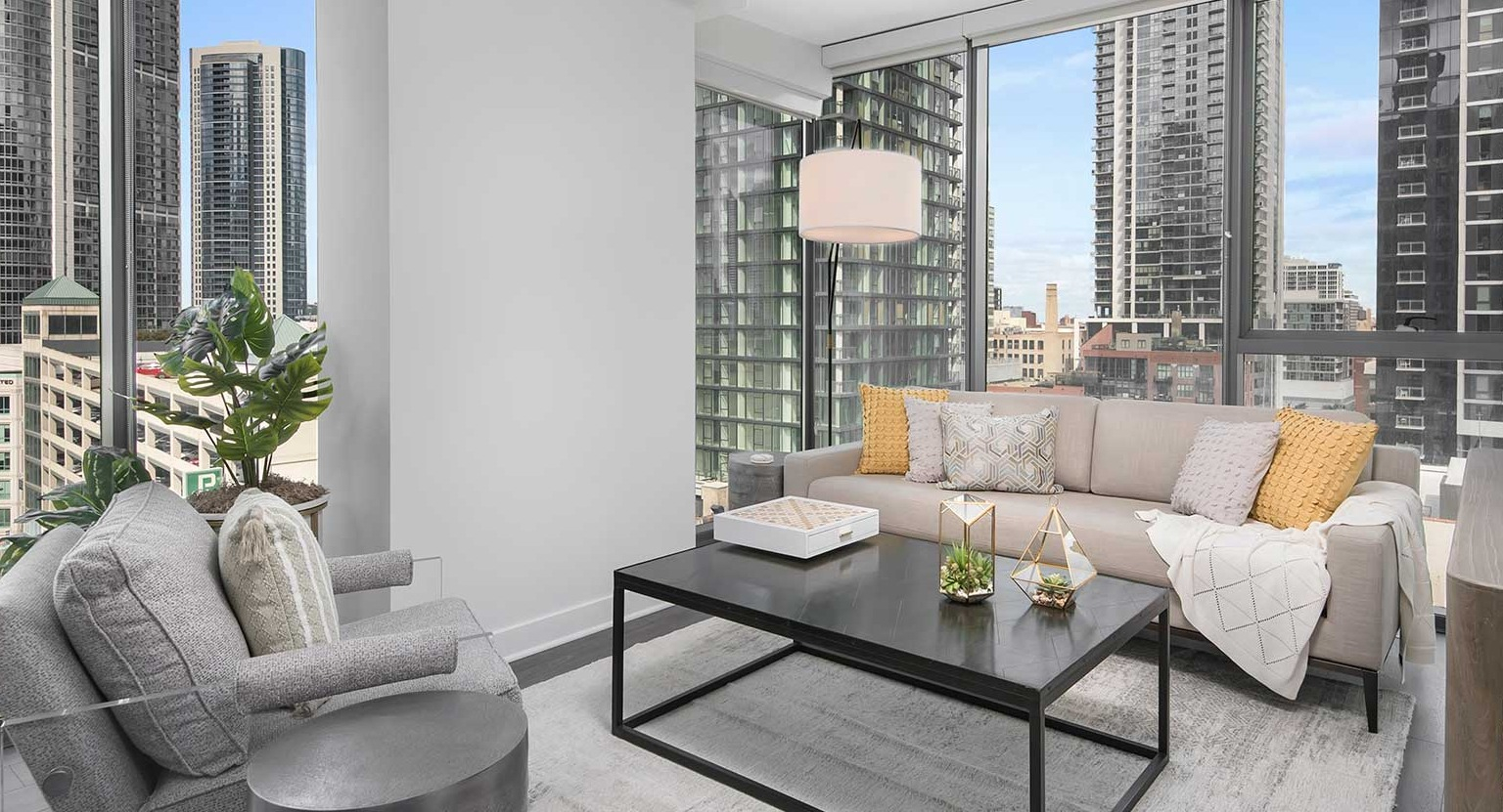 A comfortable living room at Hubbard 221, boasting modern furniture and expansive windows with a city backdrop