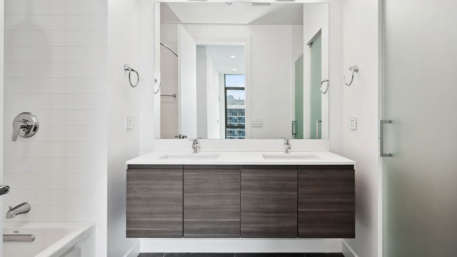 A pristine master bathroom at Hubbard 221 featuring a double vanity, large mirror, and ample space