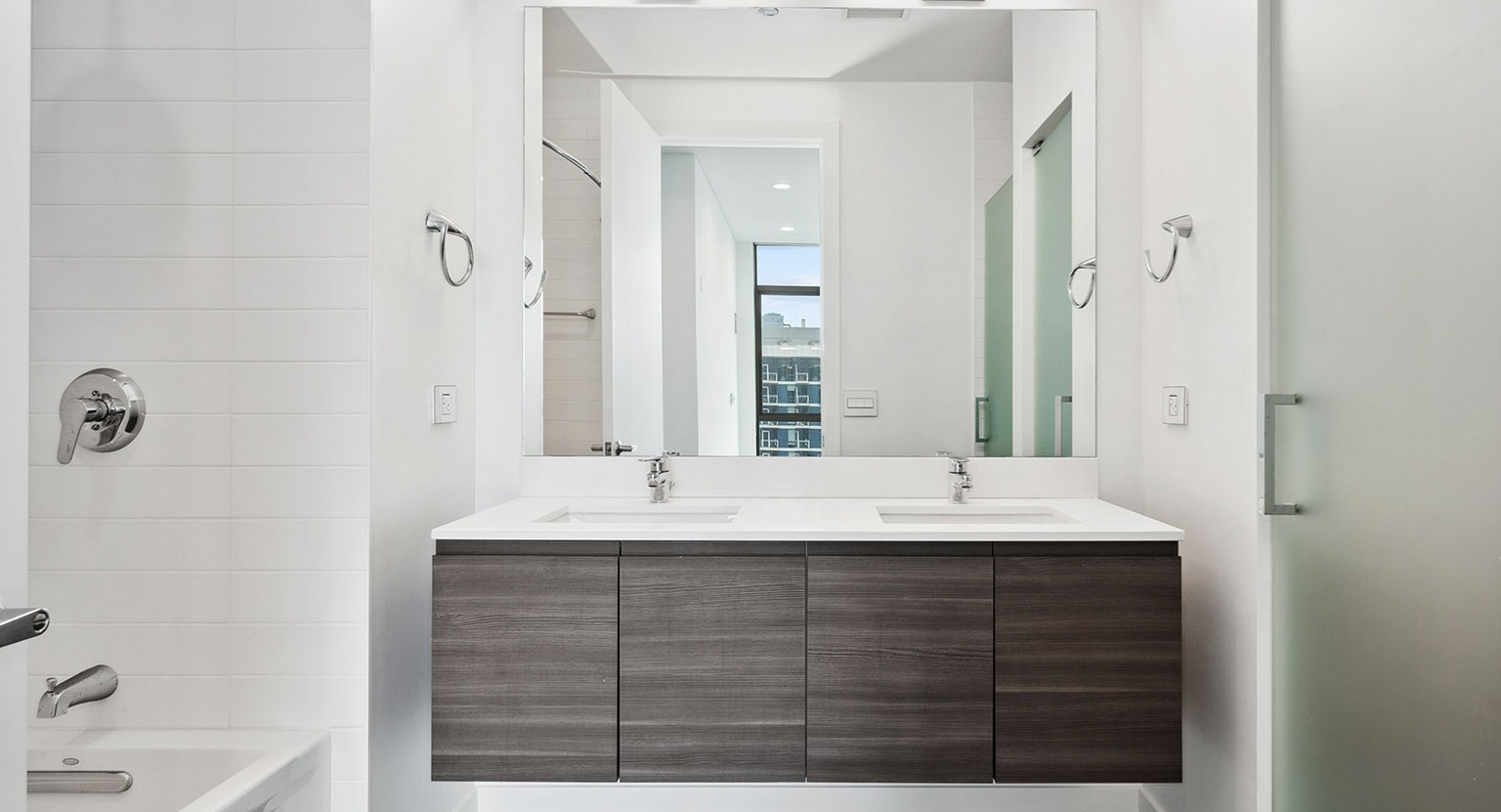 A pristine master bathroom at Hubbard 221 featuring a double vanity, large mirror, and ample space