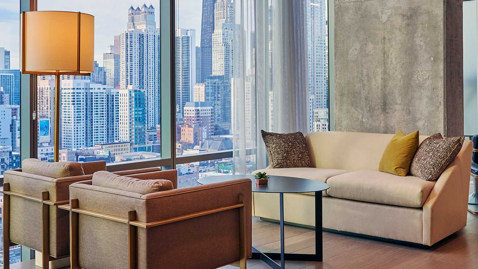 A sophisticated resident lounge at Hubbard 221 with elegant seating, modern decor, and stunning city views