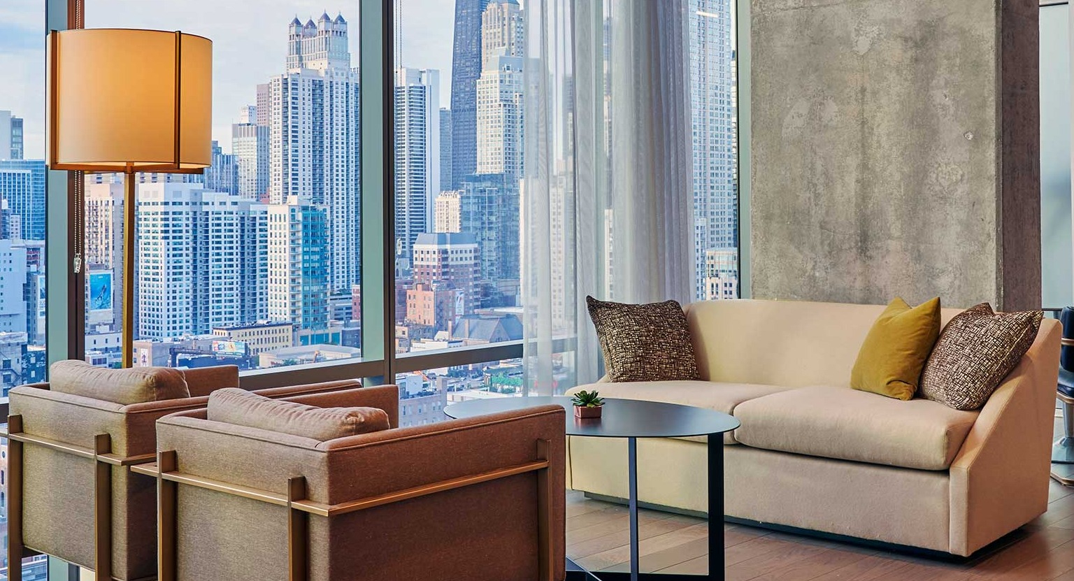 A sophisticated resident lounge at Hubbard 221 with elegant seating, modern decor, and stunning city views