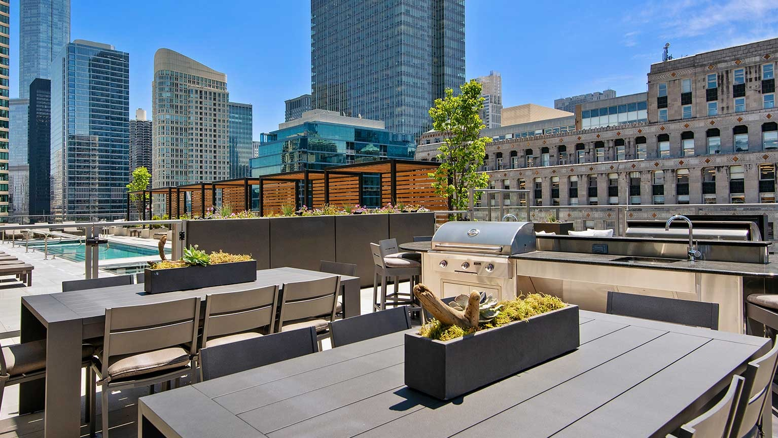 A sophisticated rooftop dining and grilling area at Hubbard 221, surrounded by modern cityscape and ample seating