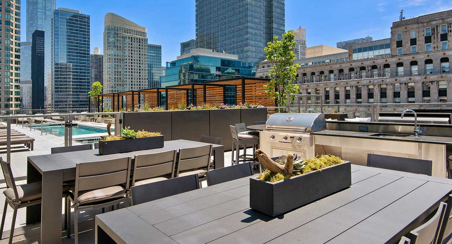 A sophisticated rooftop dining and grilling area at Hubbard 221, surrounded by modern cityscape and ample seating
