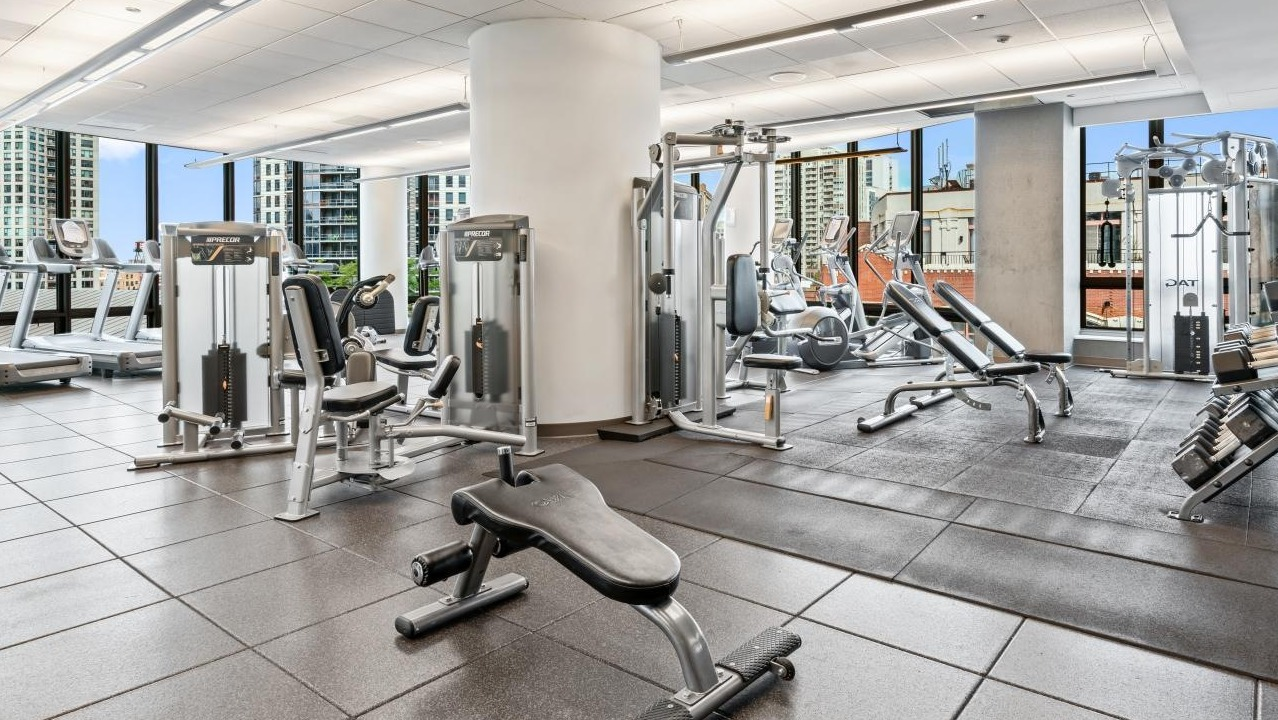 Extensive fitness center with various strength training machines, cardio equipment, and ample space for workouts at Hubbard Place in Chicago