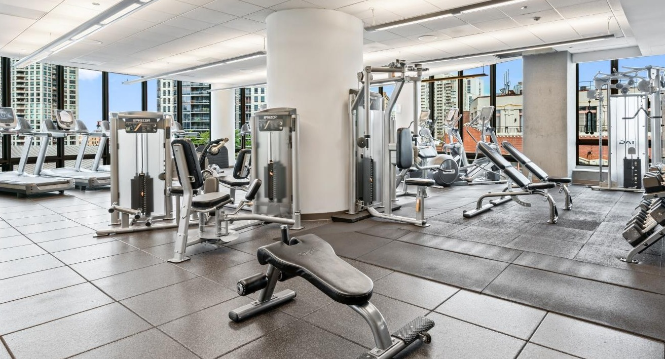 Extensive fitness center with various strength training machines, cardio equipment, and ample space for workouts at Hubbard Place in Chicago