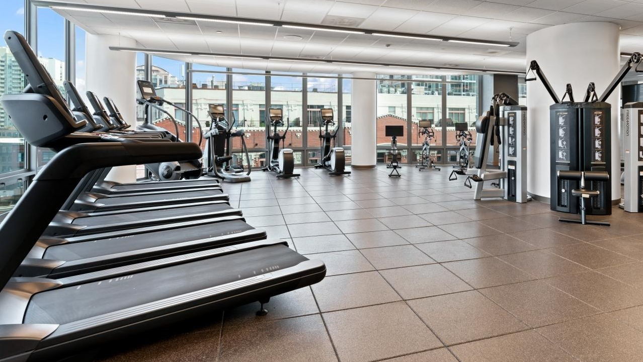 Spacious fitness center with a wide range of treadmills, weight machines, and free weights at Hubbard Place in Chicago