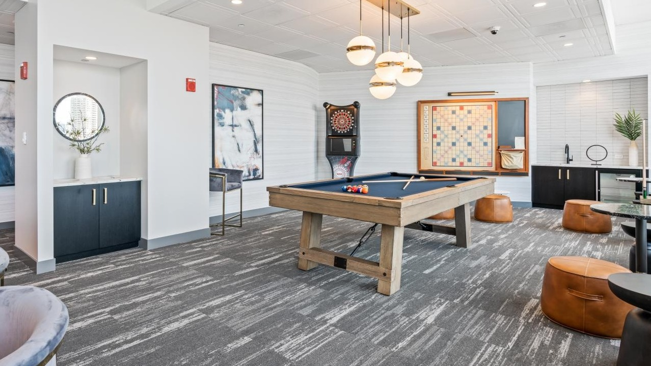 Stylish game room featuring a billiards table, comfortable seating, and various board games at Hubbard Place in Chicago