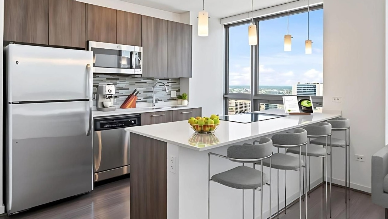 Modern kitchen with a large island, breakfast bar, stainless steel appliances, and impressive city views at Hubbard Place in Chicago