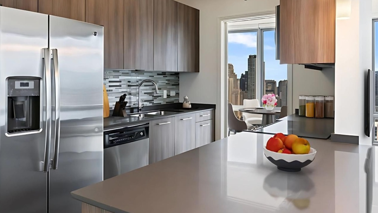 Modern kitchen equipped with stainless steel appliances, ample counter space, and a dining area with city views at Hubbard Place in Chicago