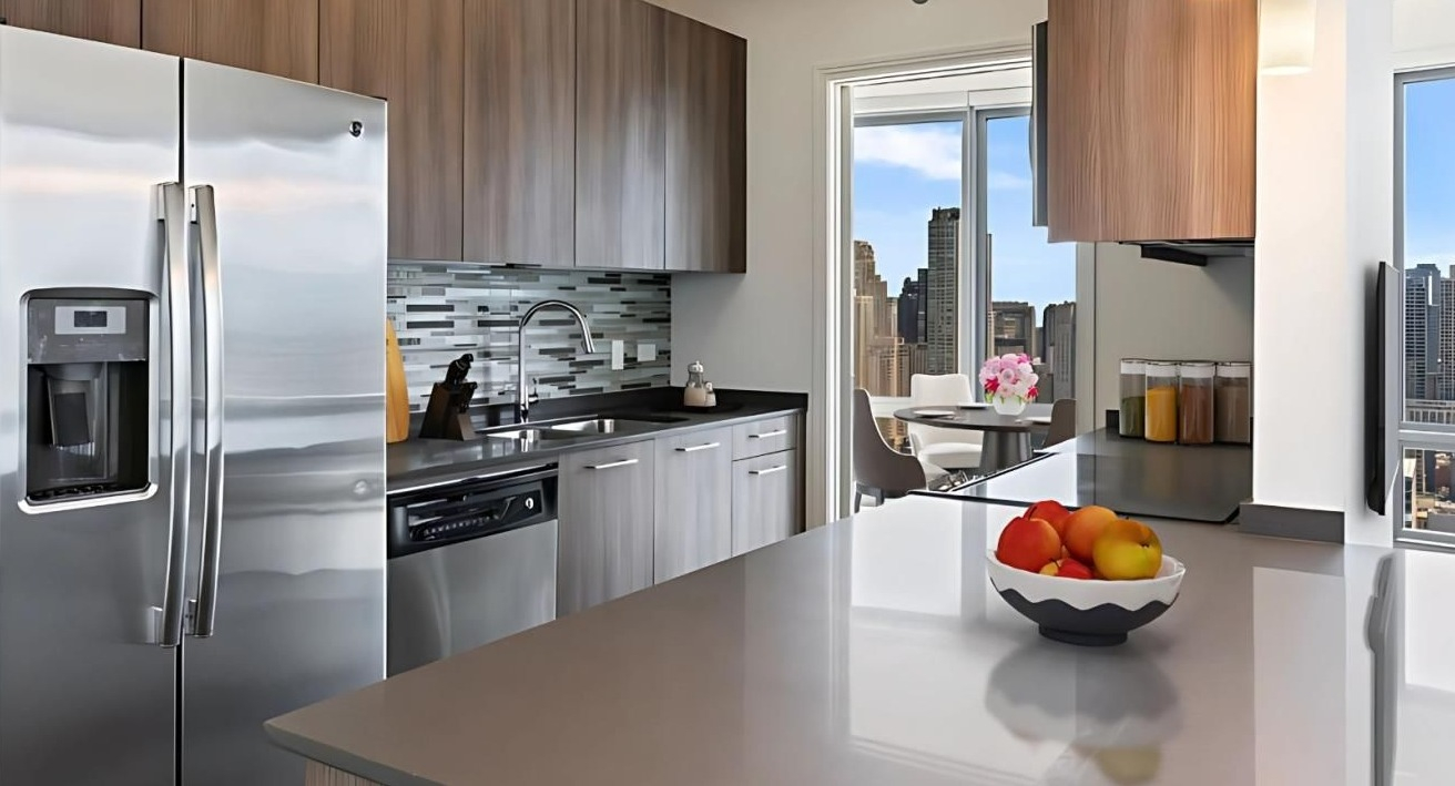 Modern kitchen equipped with stainless steel appliances, ample counter space, and a dining area with city views at Hubbard Place in Chicago