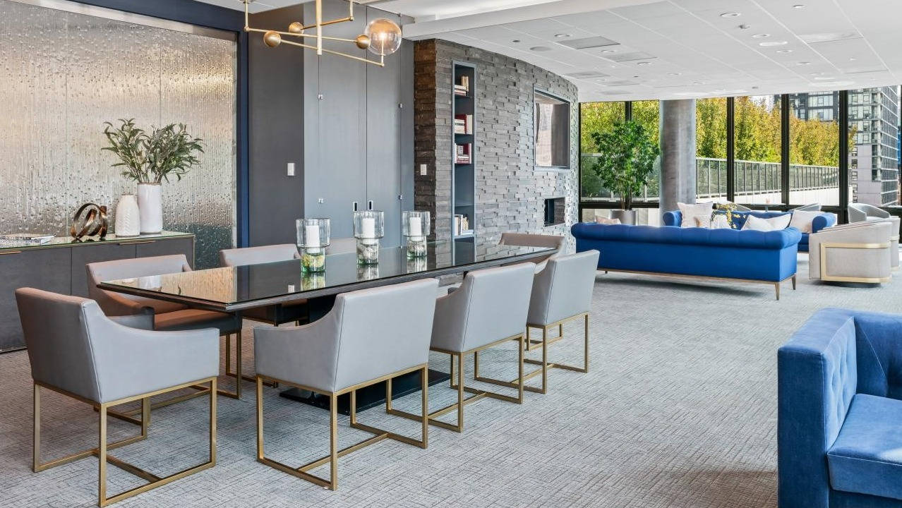 Luxurious resident lounge with a large dining table, comfortable blue sofas, and elegant decor at Hubbard Place in Chicago