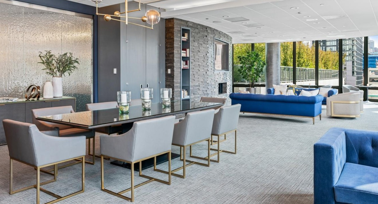 Luxurious resident lounge with a large dining table, comfortable blue sofas, and elegant decor at Hubbard Place in Chicago