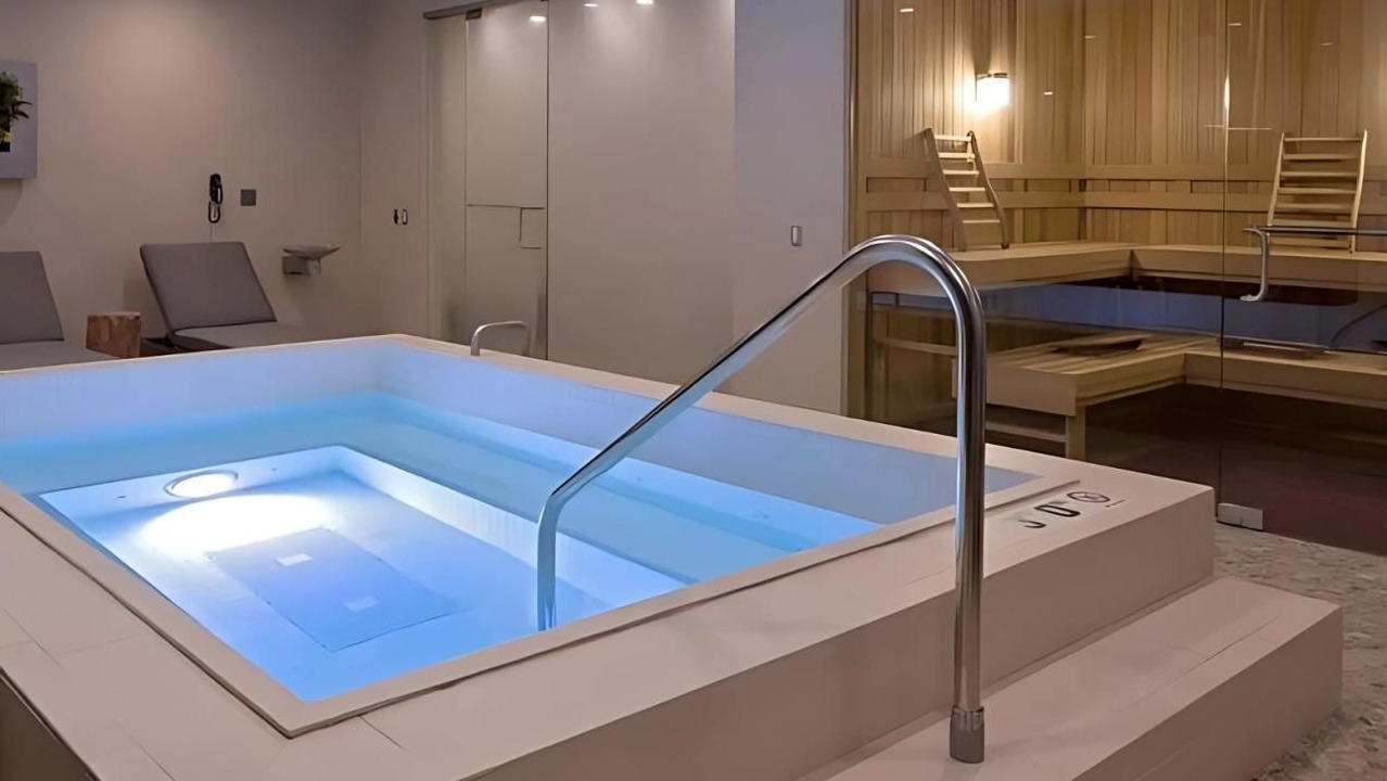 Indoor spa area featuring a glowing hot tub and a visible sauna room, perfect for relaxation at Hubbard Place in Chicago