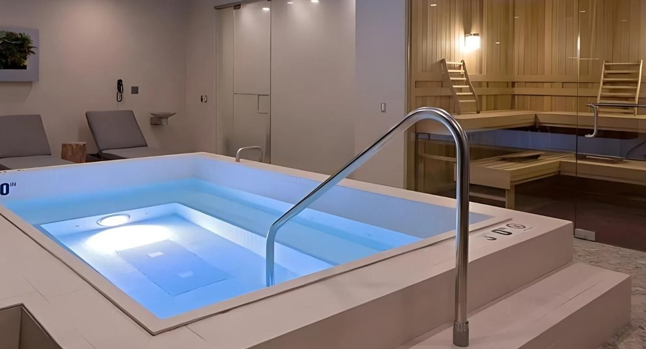 Indoor spa area featuring a glowing hot tub and a visible sauna room, perfect for relaxation at Hubbard Place in Chicago