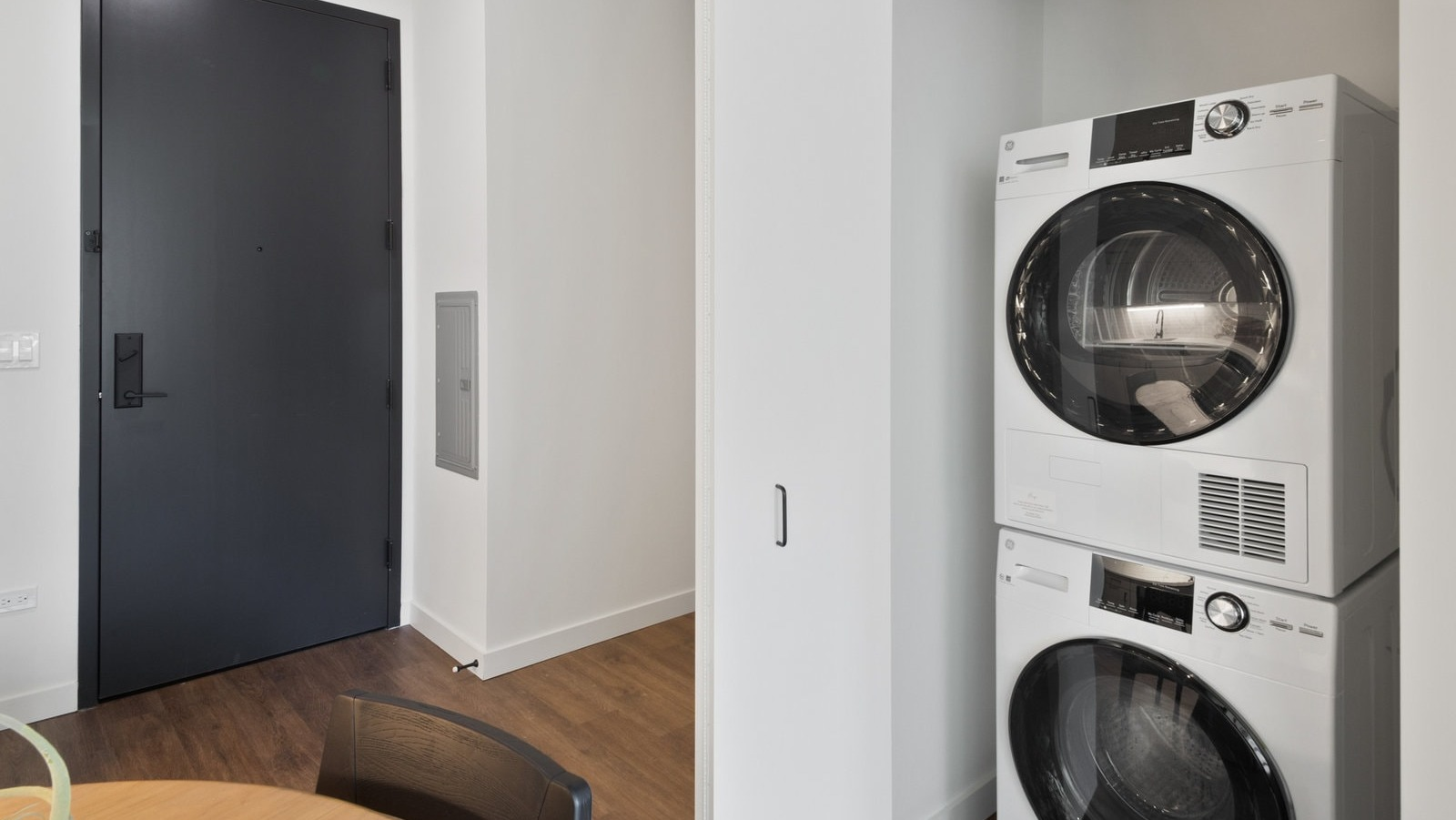 Convenient in-unit stackable washer and dryer in a bright closet space, offering modern laundry solutions at Hugo Apartments River North, Chicago