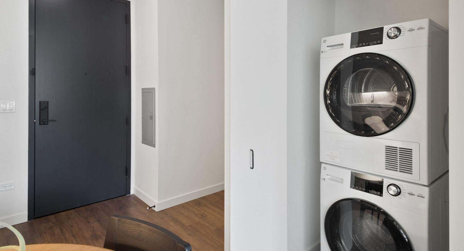 Convenient in-unit stackable washer and dryer in a bright closet space, offering modern laundry solutions at Hugo Apartments River North, Chicago