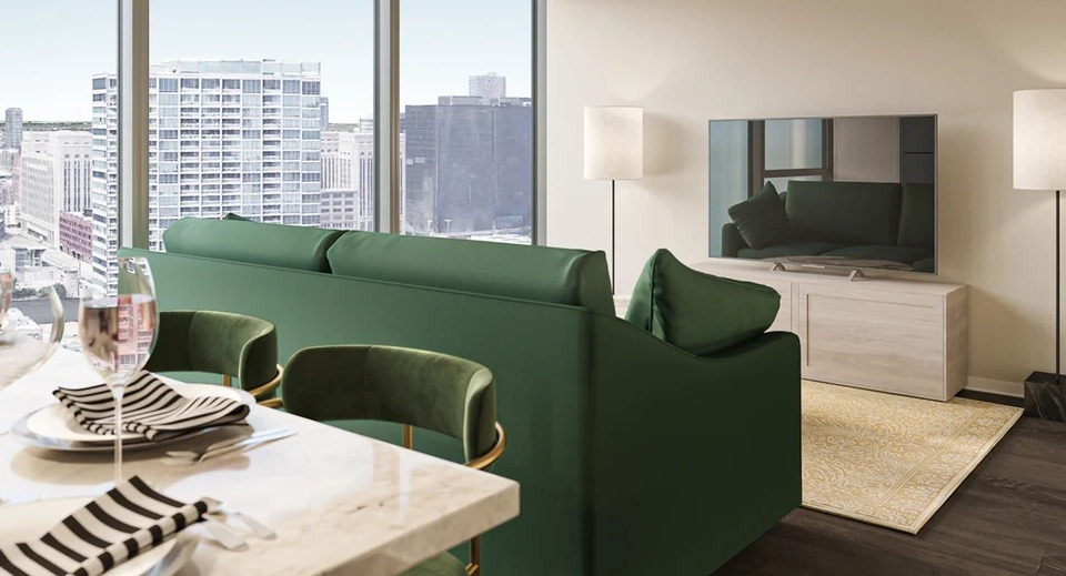 Modern dining area with green chairs and a living room with a green sofa, TV, and city views at Imprint apartments in Chicago