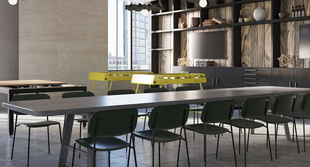 Vibrant game room with shuffleboard, foosball, TVs, and communal tables, perfect for entertainment at Imprint apartments in Chicago