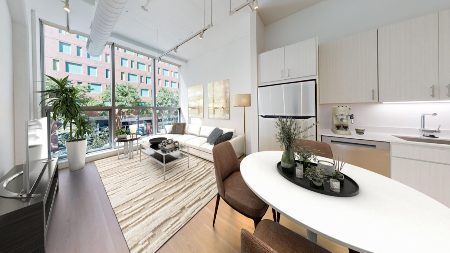 Open concept kitchen and living room featuring an oval dining table, a cozy sofa, and large windows at Imprint apartments in Chicago