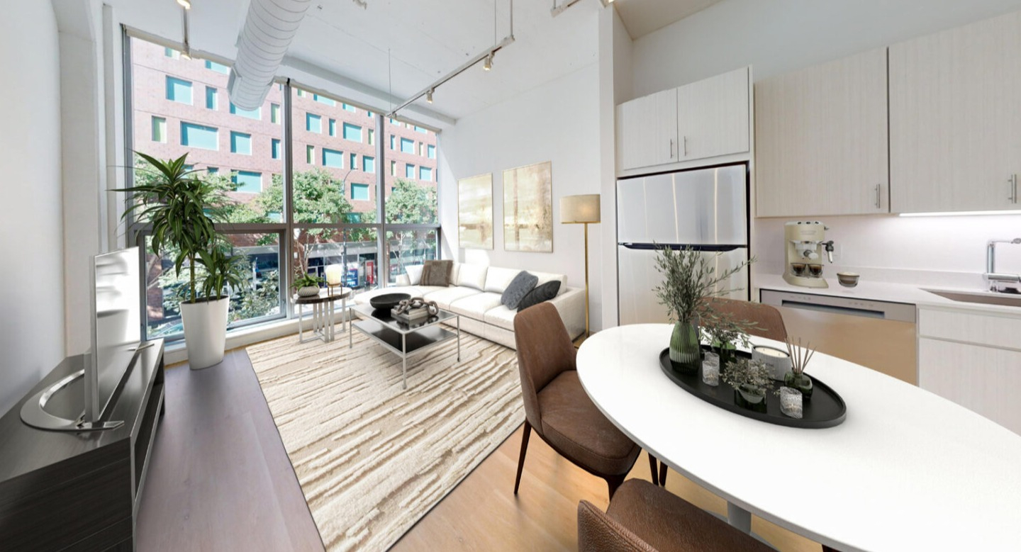 Open concept kitchen and living room featuring an oval dining table, a cozy sofa, and large windows at Imprint apartments in Chicago