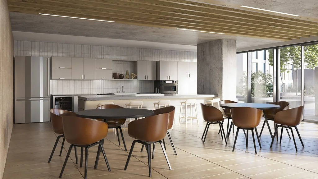 Contemporary resident kitchen and lounge area with sleek cabinetry, island seating, and communal dining tables at Imprint apartments in Chicago