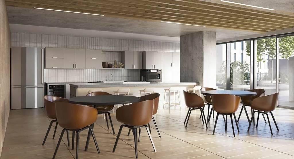 Contemporary resident kitchen and lounge area with sleek cabinetry, island seating, and communal dining tables at Imprint apartments in Chicago