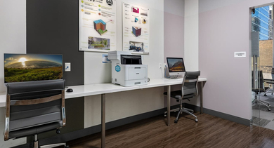 Functional business center with multiple workstations, computers, and a printer, ideal for residents at JeffJack Apartments in Chicago