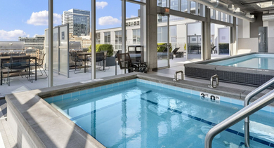 Inviting hot tub adjacent to the main pool, offering city views from the amenity deck at JeffJack Apartments in Chicago