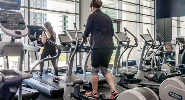 State-of-the-art fitness center with a variety of cardio machines and large windows, perfect for an invigorating workout at K2 Apartments in Chicago