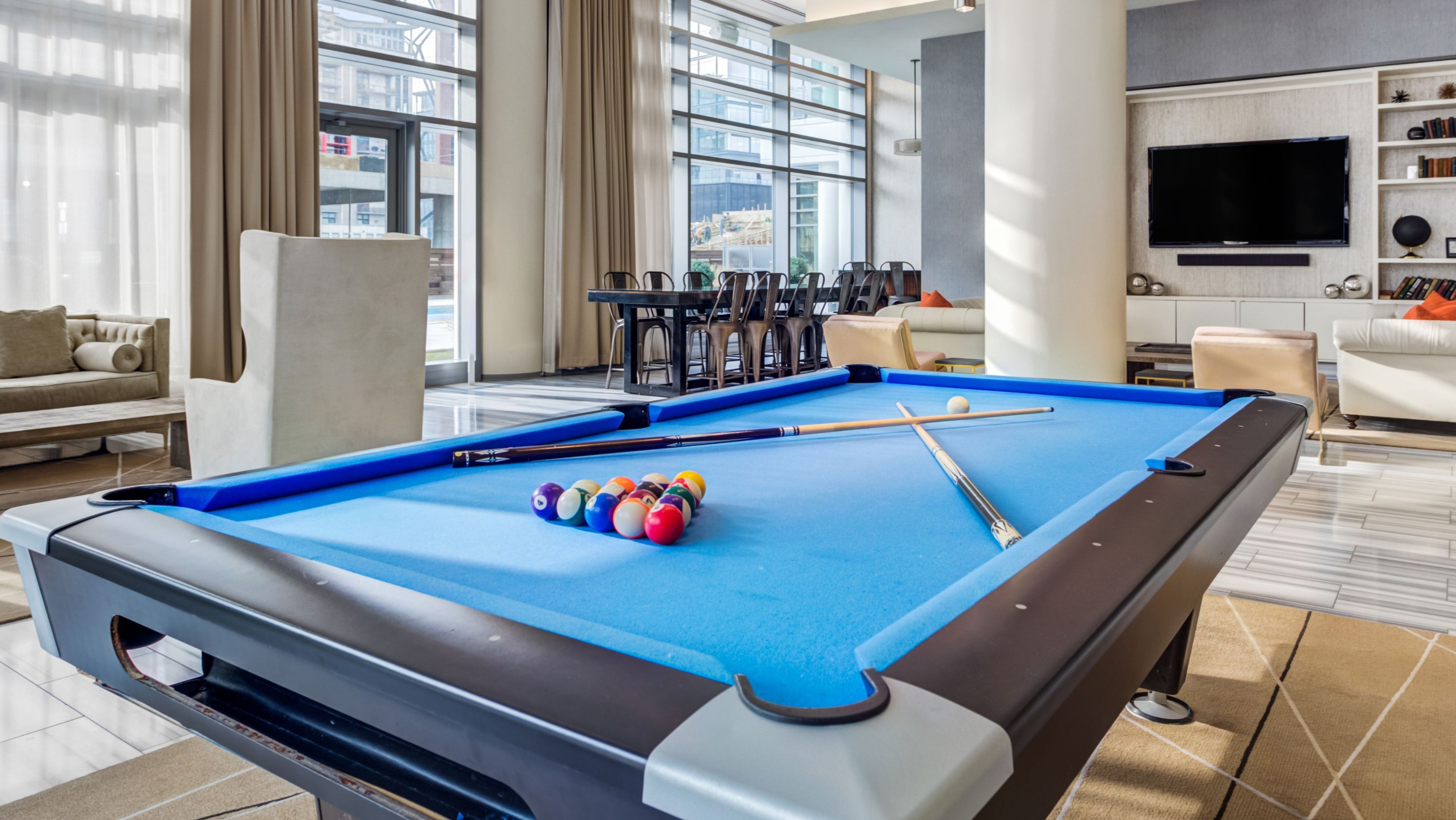 Vibrant game room and resident lounge featuring a billiards table, comfortable seating, and a TV entertainment area at K2 Apartments in Chicago