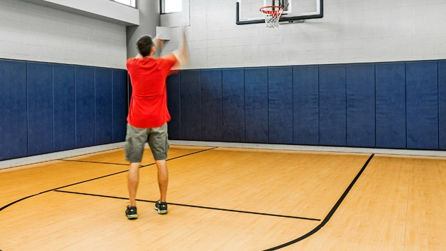Full-size indoor basketball court with padded walls, ideal for residents to enjoy sports and recreation at K2 Apartments in Chicago