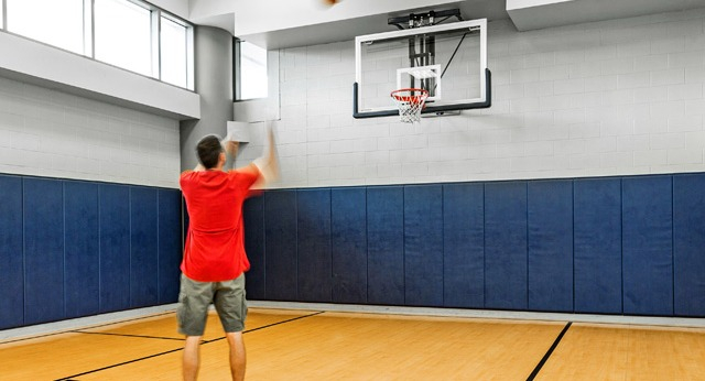 Full-size indoor basketball court with padded walls, ideal for residents to enjoy sports and recreation at K2 Apartments in Chicago