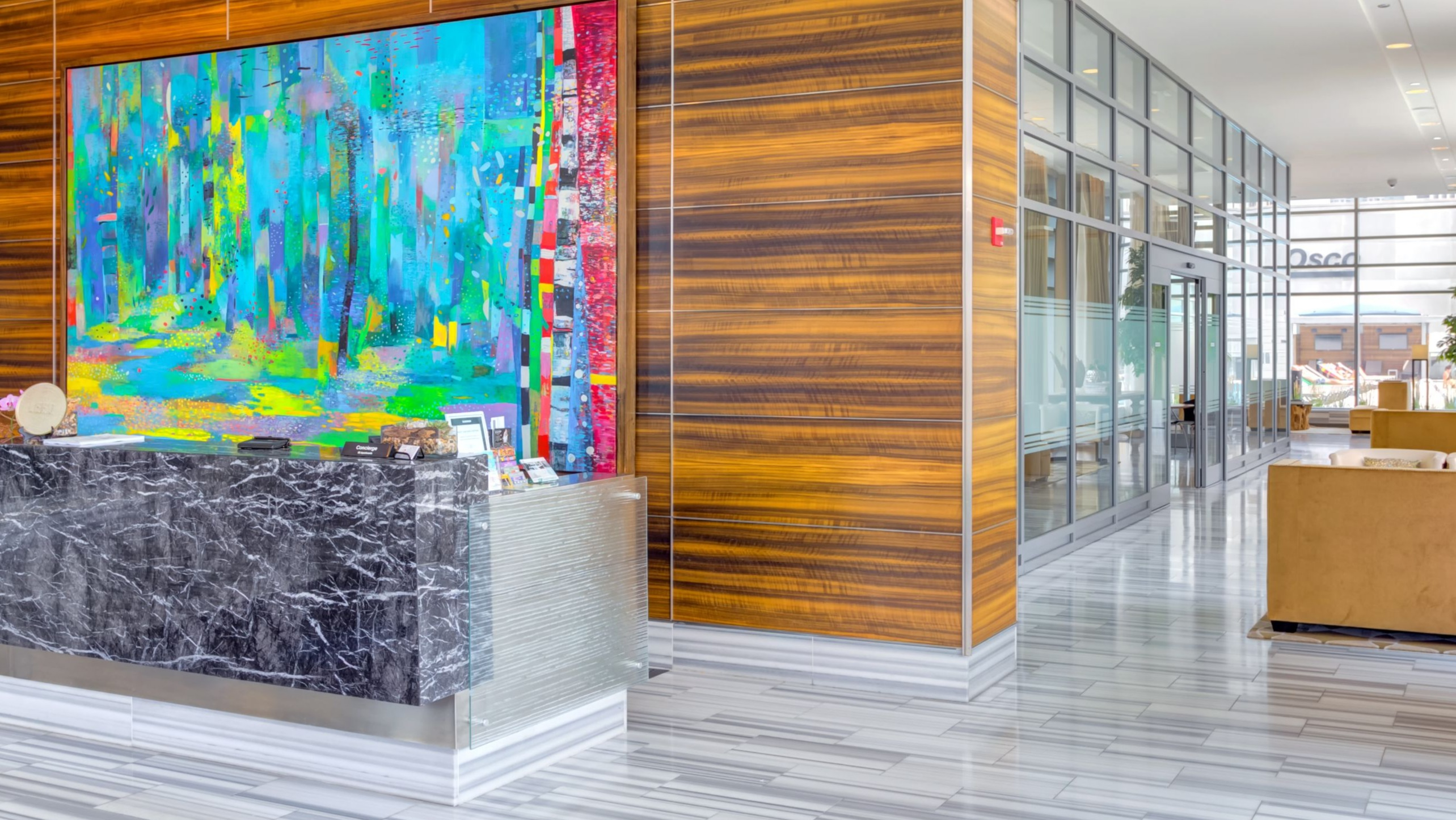 Grand and artistic lobby at K2 Apartments with a modern reception desk, vibrant artwork, and a stylish seating area in Chicago