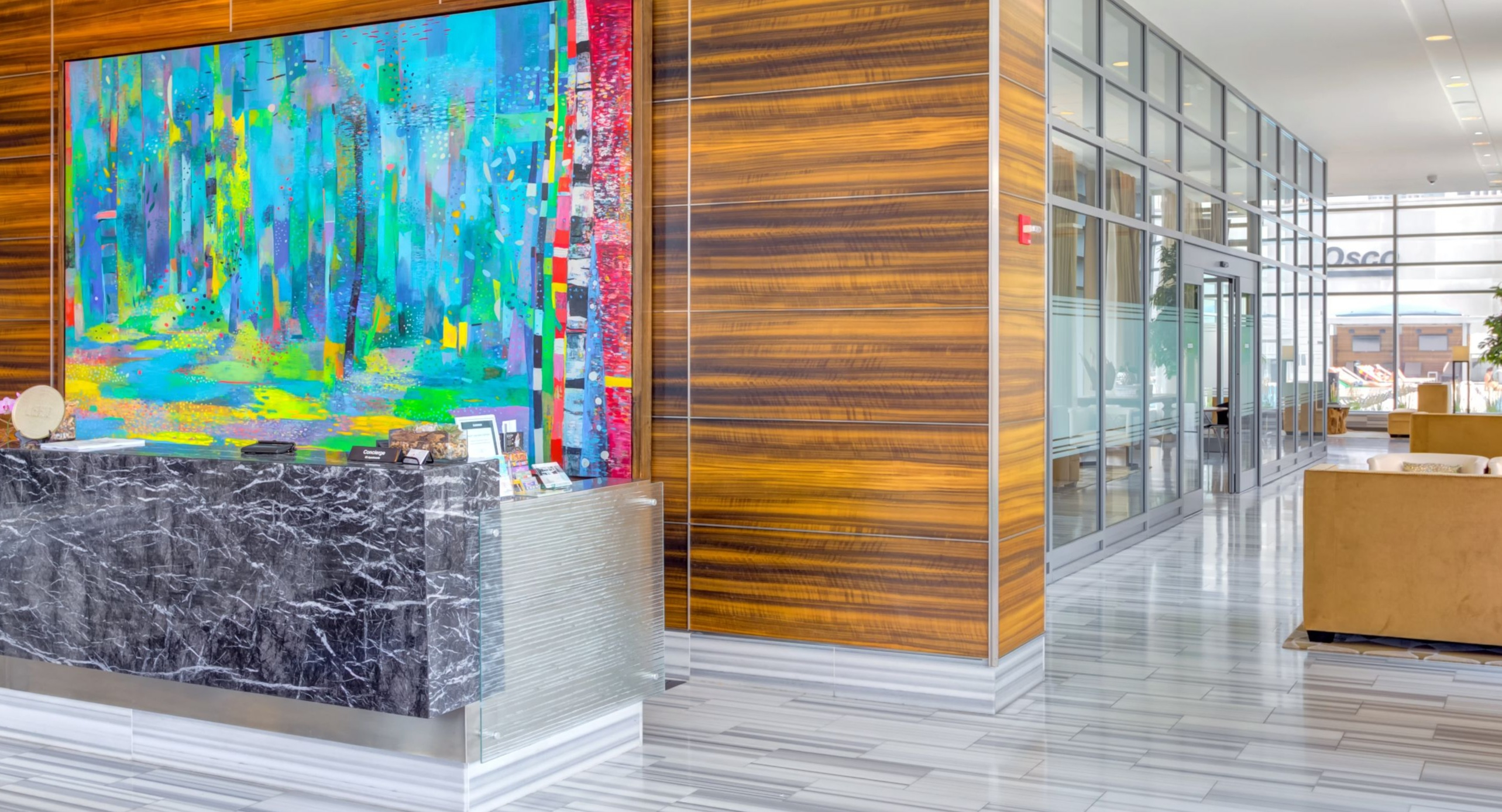 Grand and artistic lobby at K2 Apartments with a modern reception desk, vibrant artwork, and a stylish seating area in Chicago