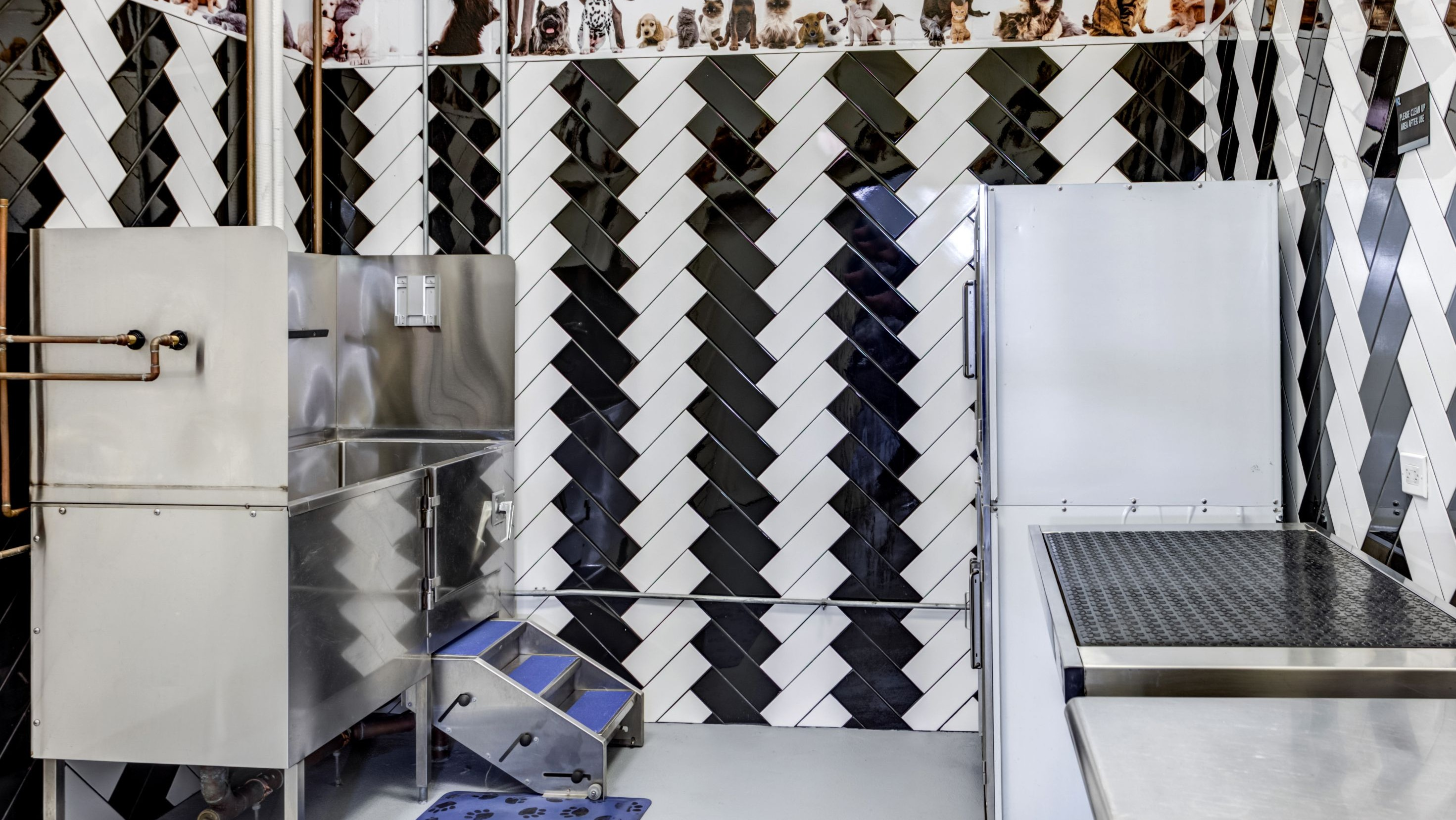 Modern pet spa and grooming station with stainless steel tubs and a stylish design, catering to furry residents at K2 Apartments in Chicago