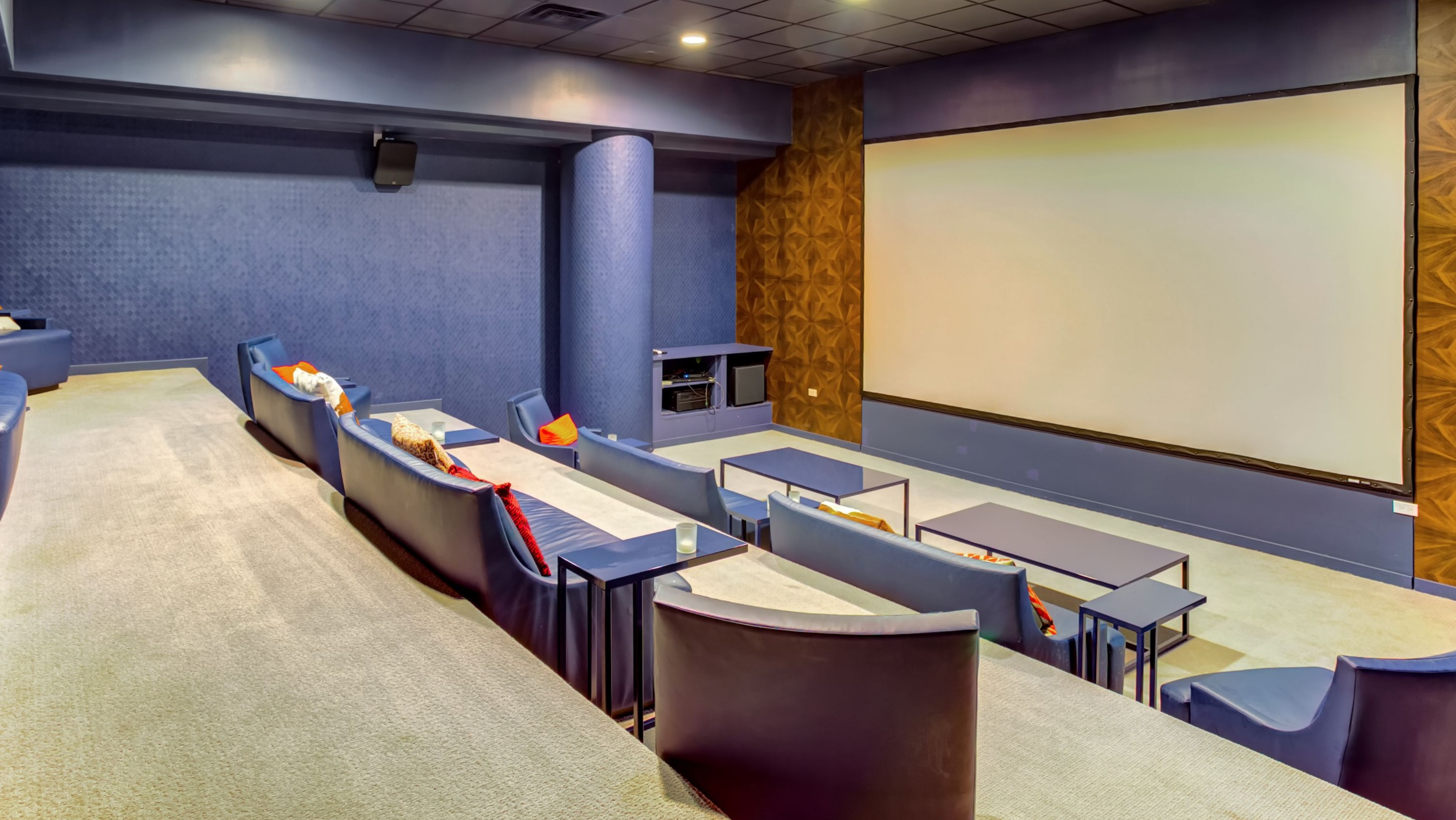 Luxurious private movie theater with comfortable tiered seating and a large projection screen, perfect for film nights at K2 Apartments in Chicago
