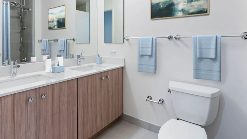 Contemporary bathroom featuring a double vanity with ample counter space, a large mirror, and a shower in Kingsbury Plaza in Chicago