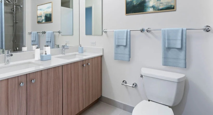 Contemporary bathroom featuring a double vanity with ample counter space, a large mirror, and a shower in Kingsbury Plaza in Chicago