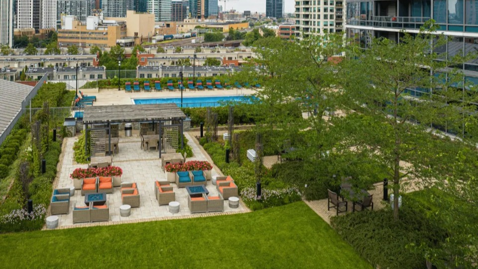 Aerial view of Kingsbury Plaza's expansive courtyard featuring a swimming pool, lounge seating, and beautifully landscaped green spaces in Chicago