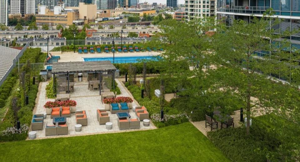 Aerial view of Kingsbury Plaza's expansive courtyard featuring a swimming pool, lounge seating, and beautifully landscaped green spaces in Chicago