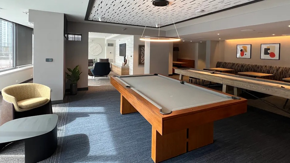 Kingsbury Plaza game room featuring a billiards table, shuffleboard, and modern design for resident entertainment
