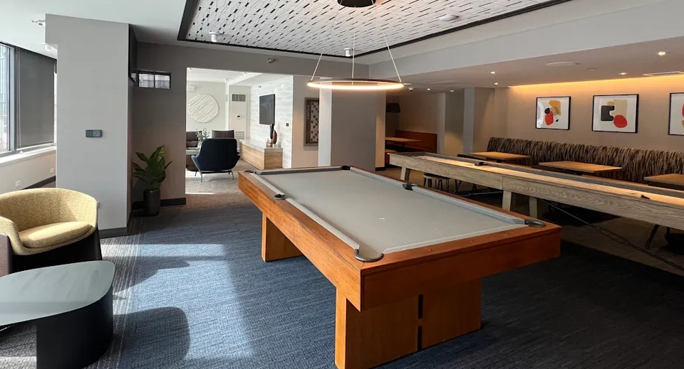 Kingsbury Plaza game room featuring a billiards table, shuffleboard, and modern design for resident entertainment