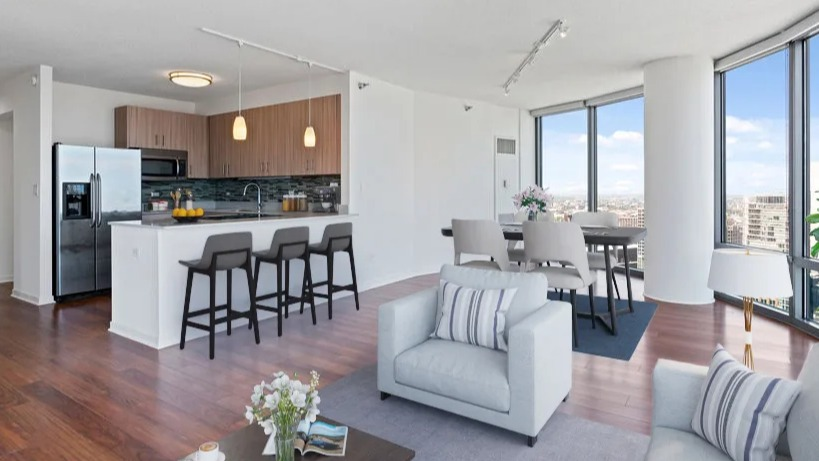 Open-concept kitchen and living area with a breakfast bar, dining space, and a bright living room with city views at Kingsbury Plaza in Chicago