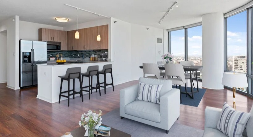 Open-concept kitchen and living area with a breakfast bar, dining space, and a bright living room with city views at Kingsbury Plaza in Chicago