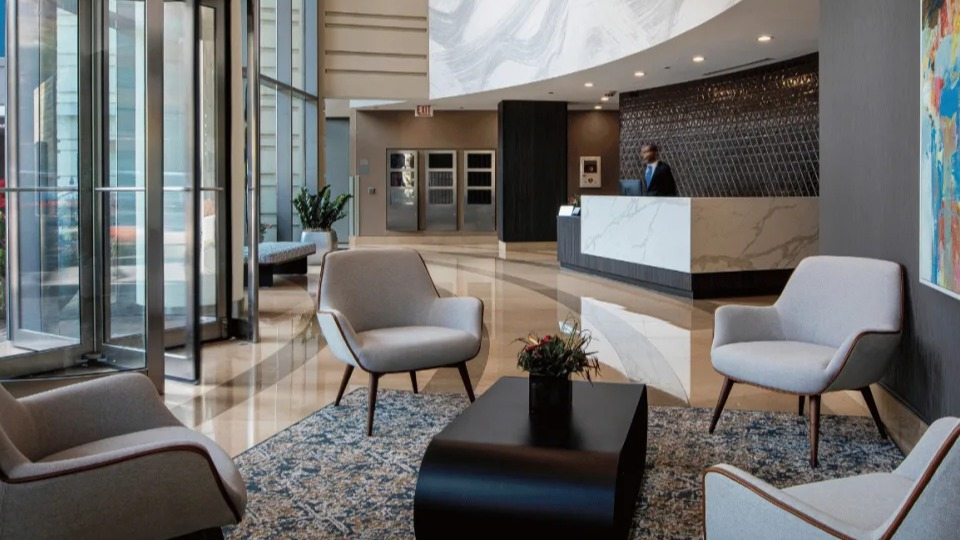 Elegant lobby and reception area at Kingsbury Plaza with comfortable seating, modern art, and a concierge desk in Chicago