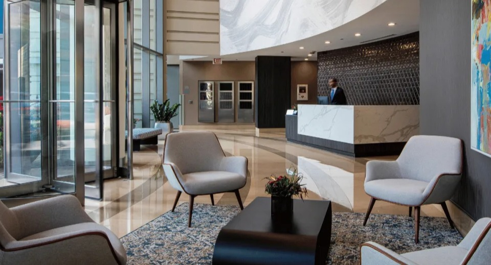 Elegant lobby and reception area at Kingsbury Plaza with comfortable seating, modern art, and a concierge desk in Chicago