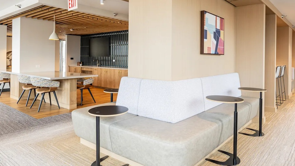Modern co-working space at Kingsbury Plaza, featuring comfortable seating, tables, and a communal kitchen area
