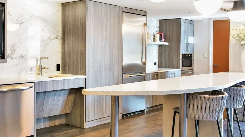 Spacious resident kitchen and lounge area with a long breakfast bar, modern appliances, and stylish seating at Kingsbury Plaza in Chicago